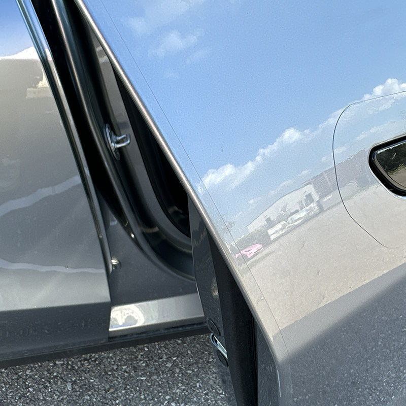 Porta del conducente aperta su Model 3/Y, vista lungo il bordo fino alla maniglia