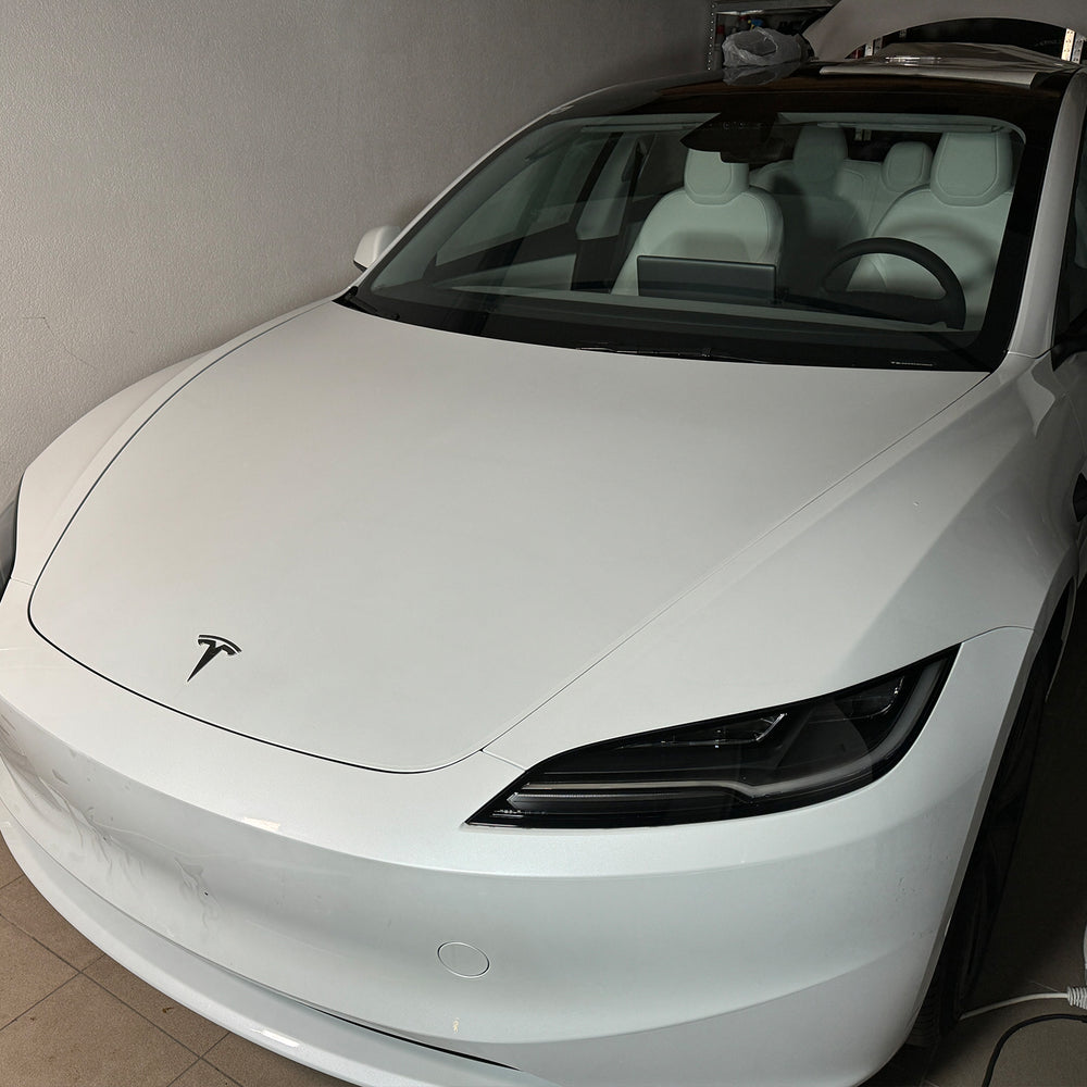 Tesla Model 3 “Highland” bianca vista di fronte in officina